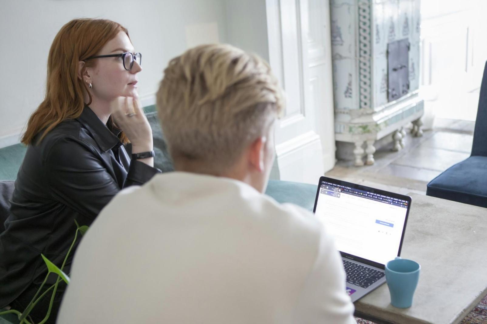 Students collaborating on economic analysis projects in modern learning environment